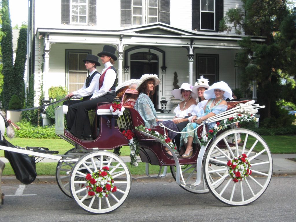 Photo of women in Victorian clothing taking horse and carriage ride
